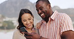 Smile, beach and couple checking phone on romantic date, weekend and relax together with online memory. Mobile app, woman and man bonding on ocean vacation with love, nature and scroll on smartphone