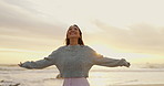 Ocean, sunset and woman with smile for freedom in vacation, weekend holiday and journey in California. Summer, female person and happy with raised hands in beach for fresh air or peace outdoors