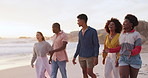 Beach, sunset and group of friends walking with waves, fun and summer holiday on tropical island. Men, women and excited people on ocean vacation together with sunshine, sand and smile on adventure