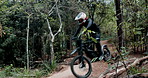 Man, forest and jump with dirt bike for extreme sport, race and fast on adventure trail in nature. Person, rider and motorcycle with speed on outdoor path for competition, contest or journey in woods
