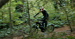 Man, forest and speed with dirt bike for extreme sport, race and adventure on nature trail. Person, rider and motorcycle with motion blure on outdoor path for competition, contest or journey in woods