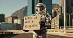 Astronaut, city and board with sign message for earth day as climate change for crisis awareness, future or mission. Person, downtown and protest billboard in suit for space problem, planet or global