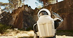 Astronaut, environment and explore mountain for planet adventure or research trip, earth or travel. Person, helmet and outdoor journey in spacesuit for expedition discovery or global, earth or forest