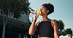 Fitness, health and woman drinking water for hydration, workout and training for wellbeing outside. Tired runner, cardio exercise with healthy liquid for resting, break and active in summer

