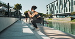 Stairs, squat and woman in city with fitness for exercise, workout and cardio training in morning. Athlete, headphones and workout outdoors with music for jump, challenge and energy for healthy body