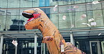 Costume, dance and city with money rain, urban office building and documents for work. Mascot, inflatable dinosaur and fun for entertainment, company culture and prank with funny business joke