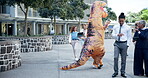 Funny, inflatable dinosaur costume and outdoor for entertainment with dancing, humor and mascot. Businesspeople, employees and paperwork for company in business precinct for customer relationships