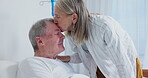 Senior, kiss and couple in hospital bed for love, support and together with sick husband. Empathy, man and woman in clinic for visit, medical and healthcare for rehabilitation from cancer surgery