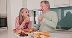 Senior, couple and relax with coffee in kitchen for bonding, retirement and conversation at breakfast in home. Elderly people, hot beverage and cheers by table with talking, wellness or morning break