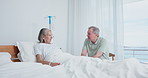 Senior, conversation and couple in hospital bed for visit, support and communication together with sick wife. Elderly man, woman and talking in clinic for wellness, medical or healthcare for recovery