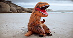 Dinosaur, costume and outdoor in beach, funny and exercise with training, fitness and muscle. Sports, silly and inflatable, mascot and performance of person, sea and goofy in mask in environment