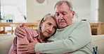 Love, hug and senior couple with support and empathy for partner with depression in home on sofa. Elderly, man and sad embrace woman with care and sympathy for grief with kindness in retirement