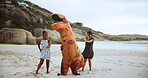 Comic, people and dinosaur with costume for dancing in beach or ocean, happiness and joy of women together. Outdoors, animal and girls moving or excited for comedy, entertainment or cheerful dance