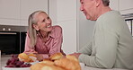 Food, laugh and senior couple in kitchen, fun and breakfast in retirement home together. Bonding, love and talking for elderly married people, romance and feeding with snack for nutrition or health