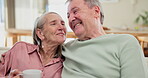 Senior, couple and hug with coffee on sofa for bonding, retirement and conversation in living room of home. Elderly people, hot beverage and embrace on couch with talking, wellness and morning break