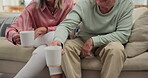 Senior, couple and relax with coffee on sofa for bonding, retirement and conversation in living room of home. Elderly people, hot beverage and cheers on couch with talking, wellness and morning break