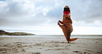 Dinosaur costume, fun and outdoor at beach with training, performance and martial arts in nature. Ocean, fitness and inflatable animal with jump for energy, workout and cardio exercise on sand