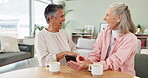 Elderly friends, table and laughing with phone for notification, funny post and bonding. Senior women, smile and happy with digital technology for networking, streaming and comedy in living room