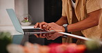 Closeup, kitchen and man with a laptop, typing and research for a recipe and ingredients with digital app. Person, home and guy with computer and internet with food blog and online reading with tech