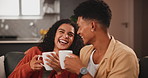 Happy couple, morning and laughing with coffee for chat, conversation or gossip on living room sofa at home. Young man or woman enjoying talk, discussion or funny joke with beverage or drink at house