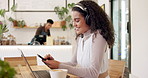 Headphones, laptop and woman on cellphone in coffee shop networking on social media or internet. Technology, smile and female creative freelancer type email on a phone and working on computer in cafe