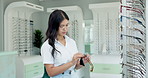 Doctor, woman and cleaning glasses at store with cloth for dust on lenses or frame and vision. Female person, optometrist and clean eyewear or spectacles with tissue for eyesight, wellbeing and care