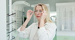 Woman, choice and mirror with glasses for optometry or vision and shopping for decision for eye care. Female person, eye health and selection for prescription, spectacles and eyewear for eyesight.