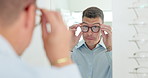 Man, reflection and mirror with glasses for optometry or vision and happy for shopping choice in store. Male person, eye health and selection for prescription, spectacles and eyewear for eyesight.