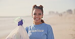 Woman, volunteer and face on beach with plastic bag for cleaning garbage, community service or sustainability. Female person, smile and trash recycling for climate change, planet or waste management