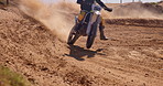 Dust, sand and bike in sports for adventure, fitness or adrenaline with desert in countryside. Motorcycle, freedom and athlete fearless for speed, challenge or fast driving by hill, outdoor or nature