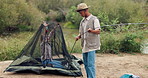 Man, woman and tent or pitching in woods for camping, wilderness and nature and relaxation. Couple, setting up and hand for hiking in park or forest, recreation with trees for marriage and adventure