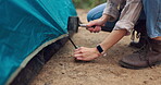 People, campsite and camping with tent outdoors, nature and survival or adventure with shelter setup for campers. Vacation, guy line for safety to ground, stake and hammer in Russian to travel