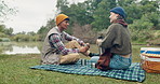 Love, coffee and couple with picnic in a forest for travel, adventure or bonding with conversation in nature. Camping, flask and calm people at a lake with tea, date or romantic, vacation or holiday