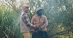 Men, friends and fishing on adventure in nature with helping hand, excited and happy for catch. People, fisherman and together for game, sport or angling with rod in countryside, forest and vacation