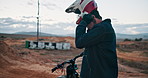 Biker, motorbike and man with helmet for safety in outdoor training for extreme sports and practice on sand. Ready, start and driver on dirtbike for dunes, race or cycling in challenge on holiday