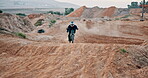 Person, motorbike and speed competition on dunes for extreme sports riding, challenge or adventure. Driver, fast and dirt hill with professional performance with adrenaline stunt, path or dirt road