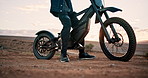 Biker, motorbike and person with gear for safety in outdoor training for extreme sports and practice on sand. Helmet, legs and driver on dirtbike for dunes, race or cycling in challenge on holiday