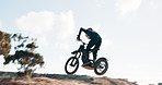 Biker, motorbike and man in air, sky or outdoor training for extreme sports, safety and practice on sand. Fly, risk or fearless driver jumping with motorcycle trick for race or cycling in challenge