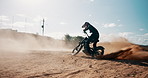 Drivers, sand or person spinning motorbike in outdoor training for extreme sports or practice in desert. Fun, dirt or biker on motorcycle for dunes, dust or donuts in performance on holiday in Dubai