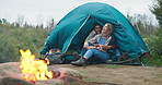 Fire, hug and couple camping in forest for travel, adventure or bonding in nature together. Sustainable living, flame and off grid people embrace in a jungle for backpacking, fun or journey in Canada