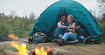 Camping, fire and couple hug in forest for travel, adventure or bonding in nature together. Sustainable living, love and off grid people embrace in a jungle for backpacking, fun or journey in Canada