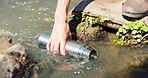 Water, bottle and river with hands of hiker for natural drink, hydration or outdoor sustainability. Closeup of traveler or adventurer trekking by pond for break, rest or fresh liquid in rain forest