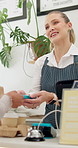 Restaurant, payment and machine with credit card by woman waitress with friendly food service. Coffee shop, pos and female server at a counter with customer for tip, purchase or cashless transaction