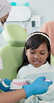 Girl, brush and teeth education with toothbrush by dentist for child development, learning and dental hygiene. Paediatrics, healthcare and teaching with equality or opportunity for affirmative action