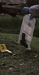 Crime scene, gun and person with evidence for investigation, collection and analysis for detective work. Forensics expert, marker and weapon for trace of fingerprints, inspection and case research.