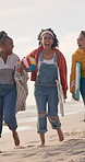 People, friends and walking on beach for picnic, travel adventure and relax on holiday together. Laughing, sand and group of women on ocean vacation with smile, diversity and weekend fun in nature