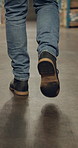 Closeup, warehouse and man with boots, walking and energy with engineer, mechanic or maintenance. Rear view, person or employee with shoes, safety or protection in factory with contractor or industry