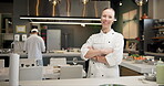 Woman, face and chef with arms crossed in kitchen or culinary cooking, hospitality or professional. Female person, smile and confidence at hotel restaurant or dinner cuisine, menu or customer service