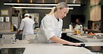 Restaurant, chef and cleaning on table in kitchen for maintenance, food safety and disinfection. Hospitality, compliance and woman with cloth on counter for hygiene, bacteria removal and sanitation