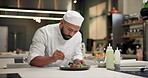 Chef, food and man plating in kitchen with garnish for gourmet meal at luxury hospitality diner. Service, catering and male culinary worker with dinner, lunch or supper at fine dining restaurant.